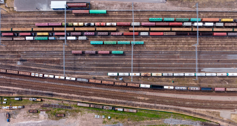 Vue du haut d’une gare de triage avec de nombreuses voies et des trains de marchandises en couleur, illustrant la capacité du Pegasus TRK Evo à recueillir des données de haute précision pour les projets d’infrastructure ferroviaire, les inspections de sécurité et la maintenance.